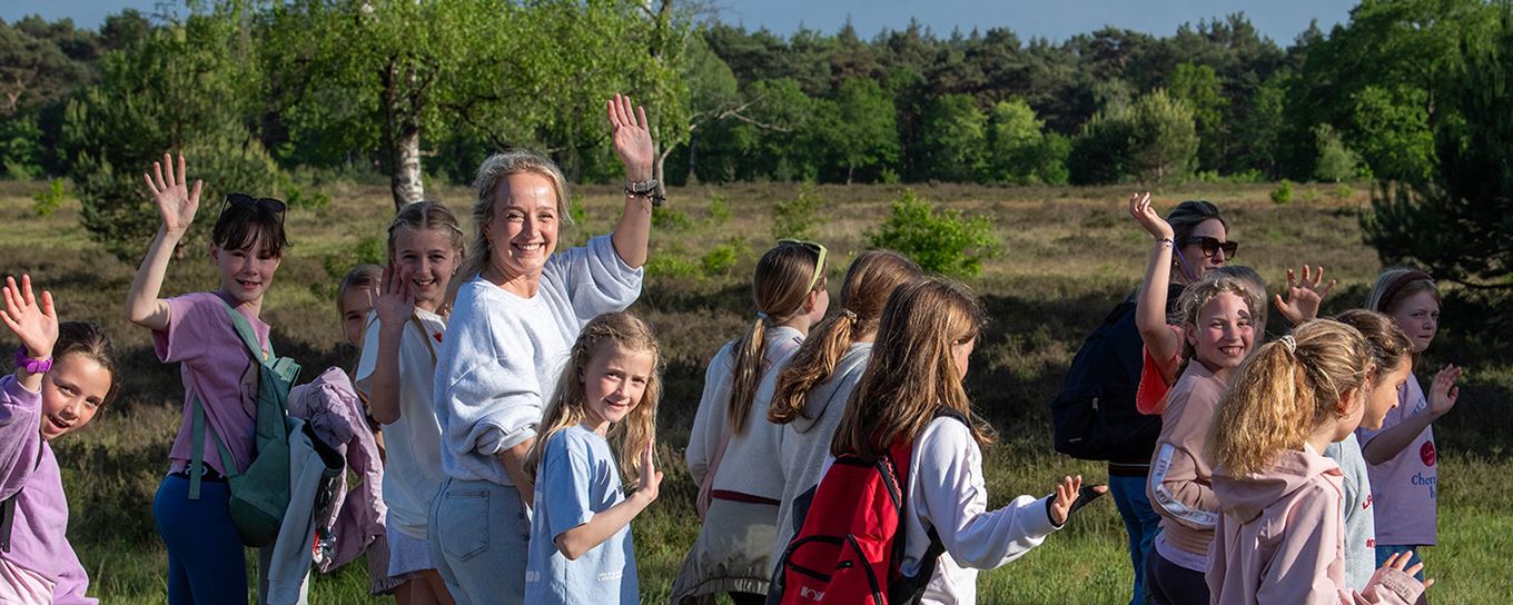 ouders en kinderen aan de wandel en zwaaiend naar de camera