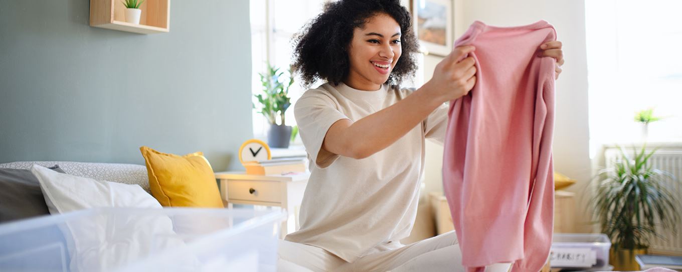 Afbeelding van een vrouw die een nieuwe trui in haar handen heeft