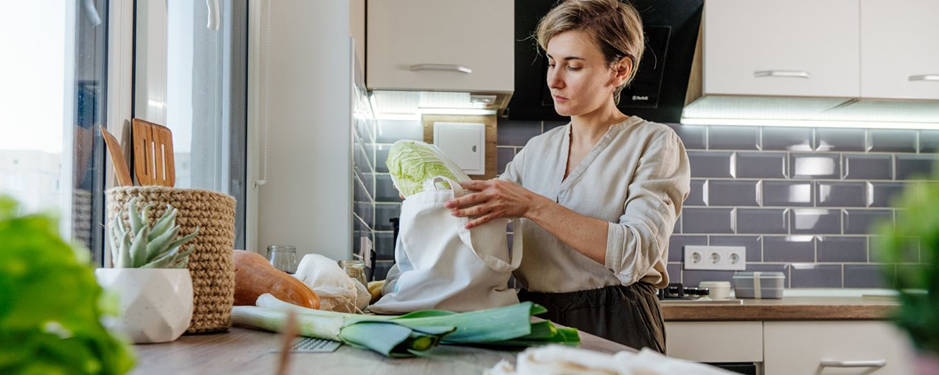 Afbeelding van een vrouw die groente uit haar tas pakt