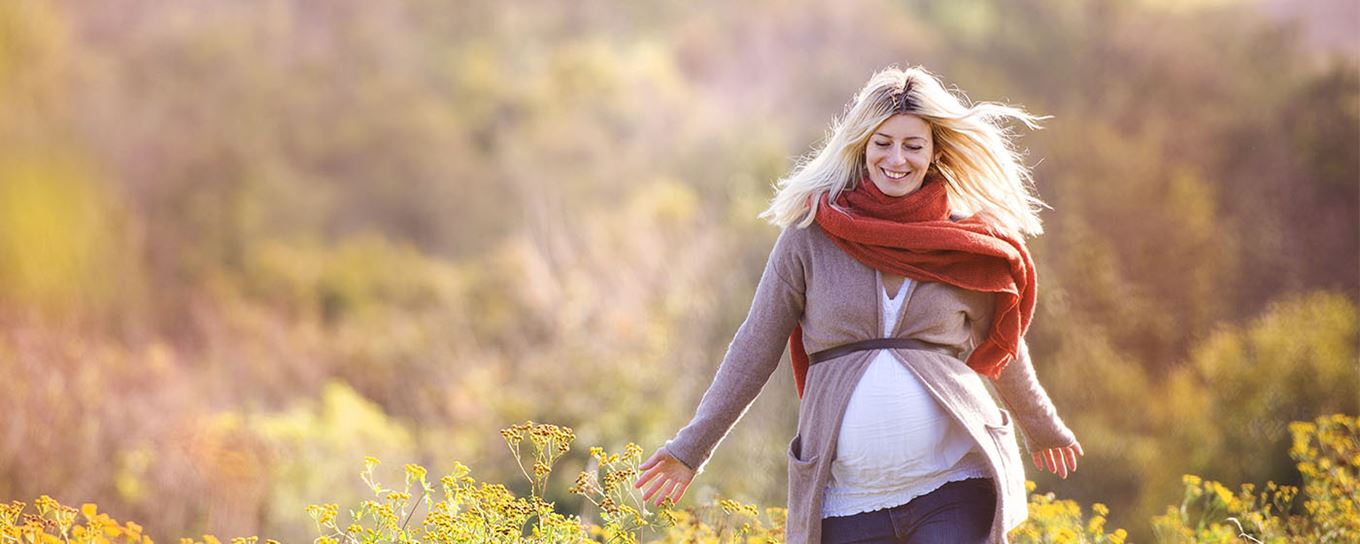 Afbeelding van een zwangere vrouw wandelend in het bos